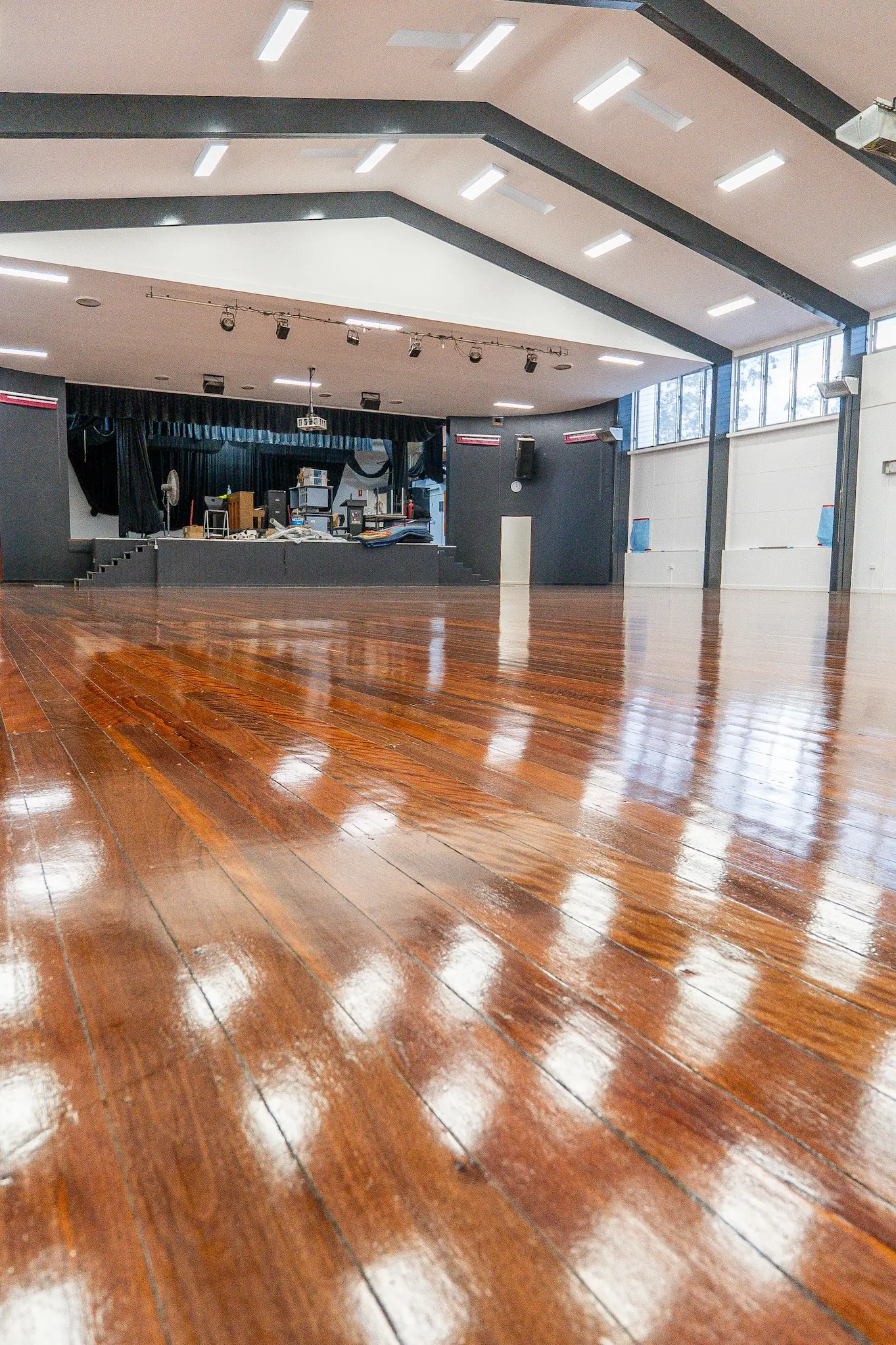 Wide view of refinished reddish-brown timber floor in a Sydney hall